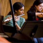Austin College students plays flute in the orchestra