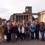 Emory & Henry College students and professors stand in front of an ancient building