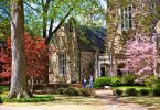 Students stand in front of a Rhodes College campus building on a fall day