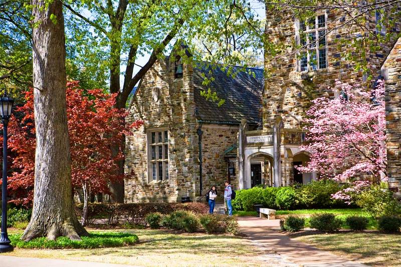 Students stand in front of a Rhodes College campus building on a fall day