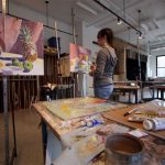 A Wheaton College student paints in an art studio