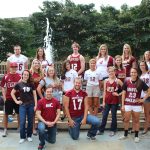 Austin College varsity athletes pose in front of a campus fountain