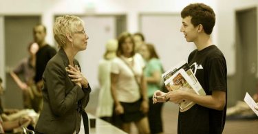 College counselor speaks with a student at a college fair