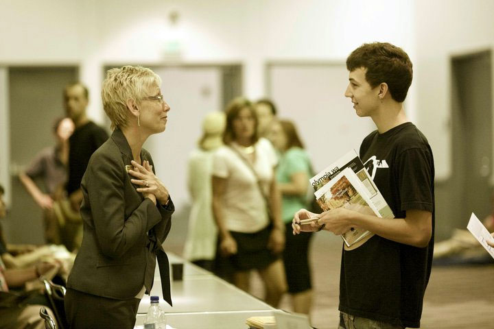 College counselor speaks with a student at a college fair