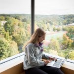 Student studies in view of Denison's football stadium and Biological Reserve