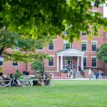 Earlham College students sit on the campus lawn