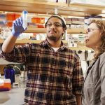 A Clark student and a professor look at a biological sample