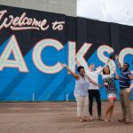 Millsaps students in front of a sign that reads Welcome to Jackson