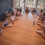 students sit around a table and discuss issues during a typical class