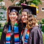 Two graduating students in their cap and gown at a Kalamazoo College commencement