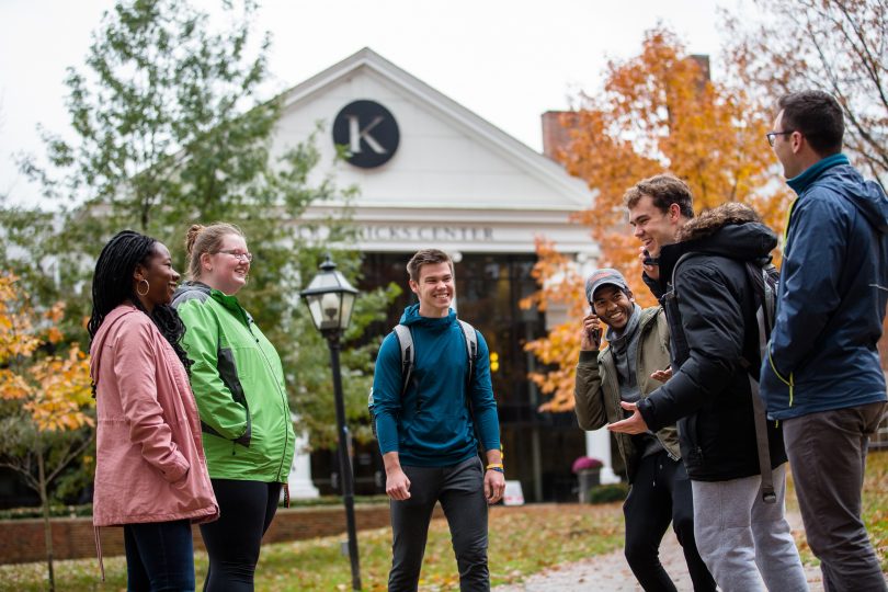 Six students gather near the Hicks Student Center at Kalamazoo College.