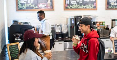 Two Guilford College students enjoy iced drinks at Rachel’s Rose Cottage, the on-campus coffee shop.